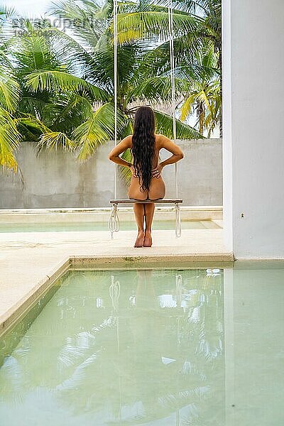 Ein schönes brünettes Nacktmodell schwingt am Pool auf der Halbinsel Yucatán in der Nähe von Merida  Mexiko  Mittelamerika