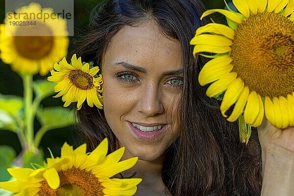 Eine schöne Green Eyed Brunette Modell posiert im Freien in einem Feld von Sonnenblumen