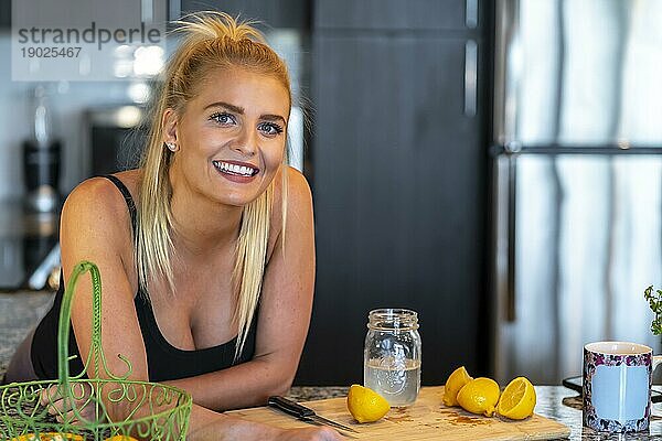 Ein wunderschönes blondes Model bereitet eine Mahlzeit zu  bevor es zur Arbeit geht