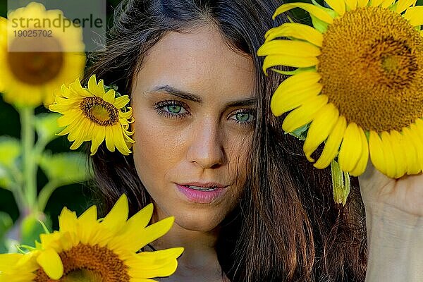 Eine schöne Green Eyed Brunette Modell posiert im Freien in einem Feld von Sonnenblumen