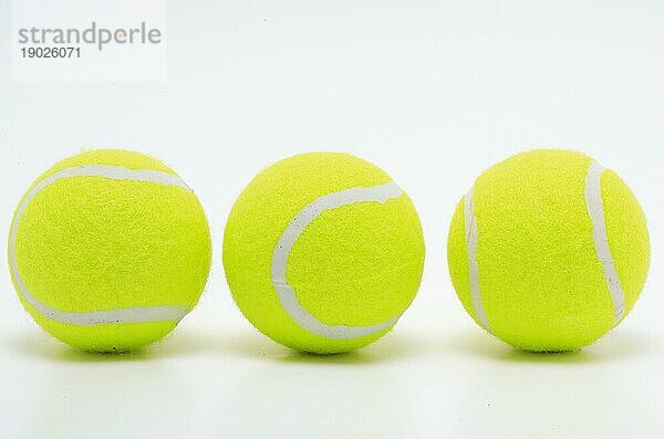 Sportgerät  drei gelbe Tennisbälle in einer Reihe