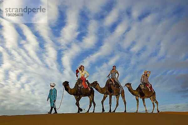 Drei Passagiere und ihr Betreuer reisen durch die Wüste Sahara in Marokko