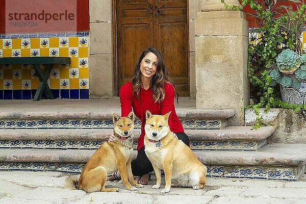 Eine wunderschöne Hispanic Brunette Modell posiert im Freien mit ihren Hunden in häuslicher Umgebung