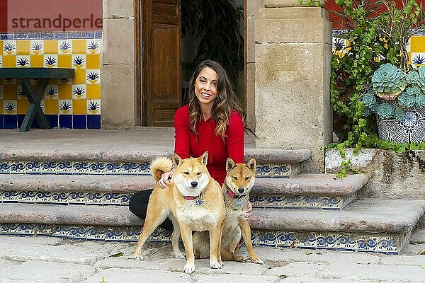 Eine wunderschöne Hispanic Brunette Modell posiert im Freien mit ihren Hunden in häuslicher Umgebung