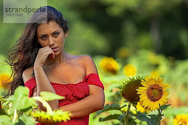 Eine schöne Green Eyed Brunette Modell posiert im Freien in einem Feld von Sonnenblumen