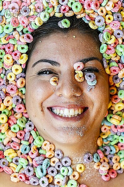 Ein wunderschönes junges hispanisches Model ist mit Frühstücksflocken bedeckt und zeigt nur ihr Gesicht