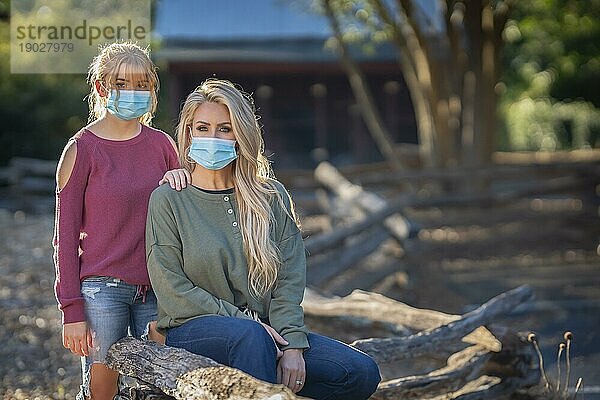 Eine Mutter und ihre Tochter genießen einen Tag im Freien  während sie während der Covid 19 Pandemie Masken tragen und einen Sicherheitsabstand zu anderen Menschen einhalten