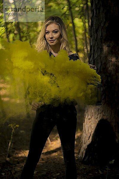 Ein wunderschönes blondes Modell posiert im Freien  während Rauch aus einer Laterne strömt