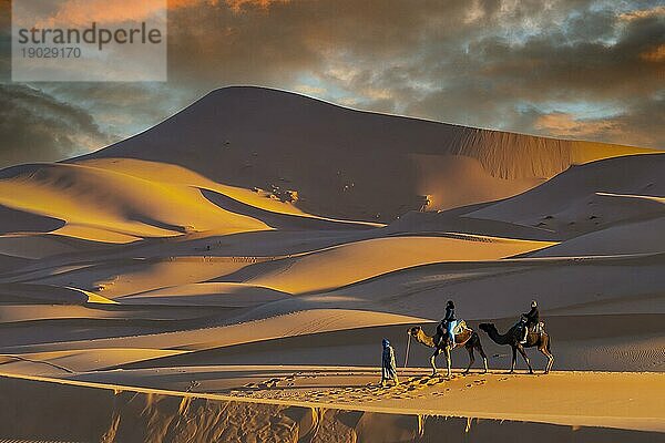 Zwei Passagiere und ihr Betreuer reisen durch die Wüste Sahara in Marokko