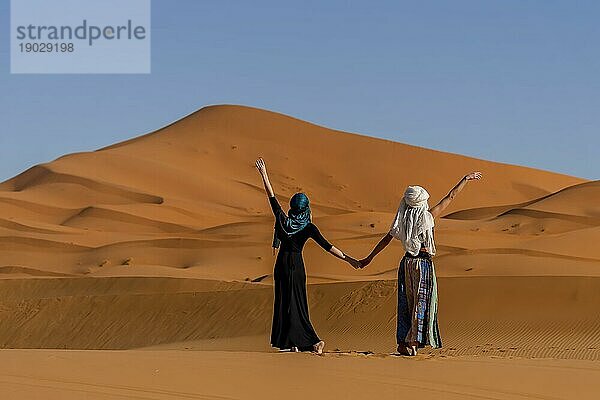 Ein schönes Model posiert vor den Sanddünen in der großen Saharawüste in Marokko