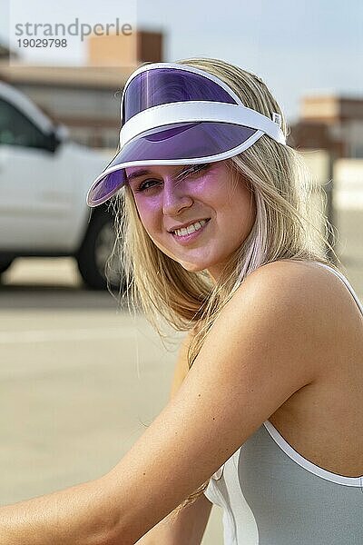 Ein wunderschönes junges blondes Model genießt einen Sommertag mit ihrem Skateboard