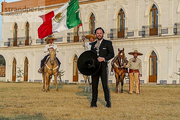 Ein stattlicher mexikanischer Charro posiert vor einer Hazienda in der mexikanischen Landschaft