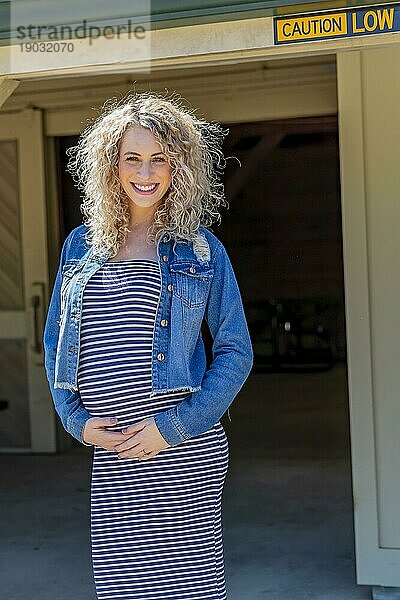 Ein schwangeres blondes Model posiert für Bilder im Freien