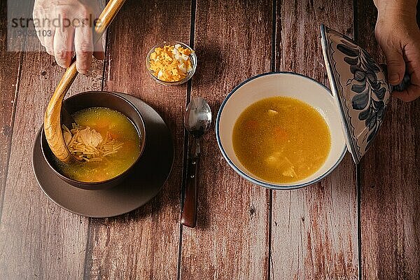 Frau serviert Nudelsuppe mit Huhn und hartgekochtem Ei