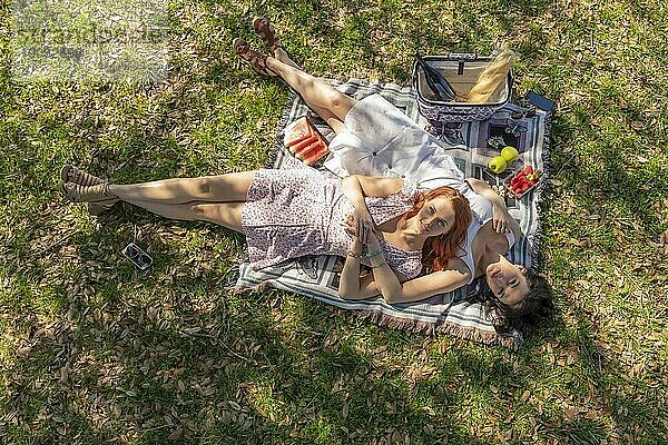 Zwei wunderschöne Modelle genießen die Gesellschaft des anderen an einem Herbsttag mit einem Picknick