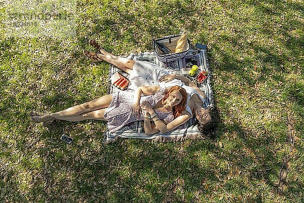 Zwei wunderschöne Modelle genießen die Gesellschaft des anderen an einem Herbsttag mit einem Picknick