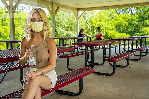 Ein wunderschönes junges blondes Model genießt einen Tag im Freien  während es während der Covid 19 Pandemie einen Sicherheitsabstand zu anderen Menschen einhält