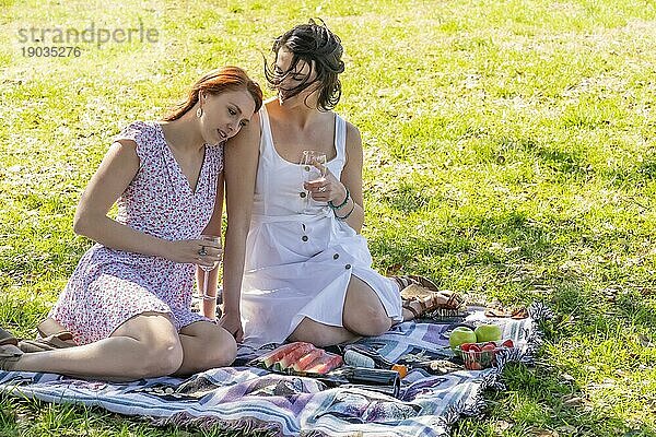 Zwei wunderschöne Modelle genießen die Gesellschaft des anderen an einem Herbsttag mit einem Picknick