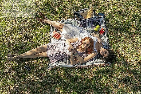 Zwei wunderschöne Modelle genießen die Gesellschaft des anderen an einem Herbsttag mit einem Picknick