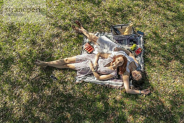 Zwei wunderschöne Modelle genießen die Gesellschaft des anderen an einem Herbsttag mit einem Picknick