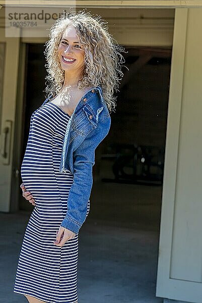 Ein schwangeres blondes Model posiert für Bilder im Freien