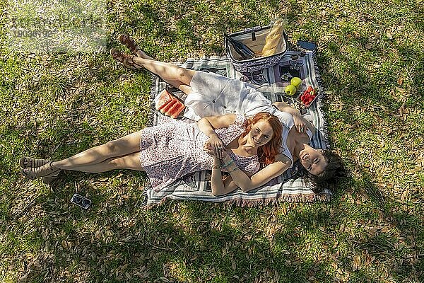 Zwei wunderschöne Modelle genießen die Gesellschaft des anderen an einem Herbsttag mit einem Picknick