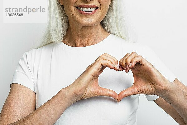 Smiley Frau zeigt Herz mit Händen. Auflösung und hohe Qualität schönes Foto