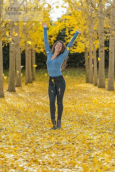 Ein schönes brünettes Modell mit gelbem Herbstlaub