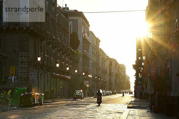 Morgendlcihes Gegenlicht  Straße  Sonne als Stern  Roller  Autos  Laternen  Catania  Altstadt  Barocke Altstadt  Ostküse  Sizilien  Italien  Europa