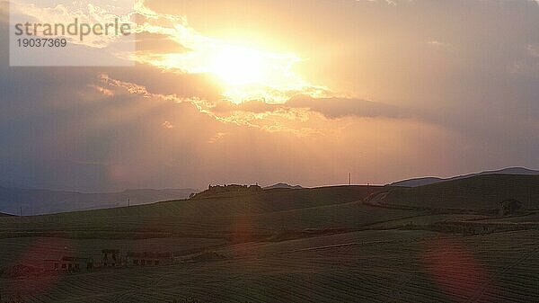 Abendliches Gegenlicht  kahle Hügellandschaft  wolkiger Himmel  einzelne Bäume  Nationalpark Madonie  Herbst  Spätsommer  Sizilien  Italien  Europa