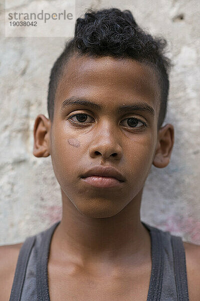 Porträt eines ernsten jungen kubanischen Jungen  der an einer Wand im Project Cuba Old Havana  La Havana  Kuba  lehnt