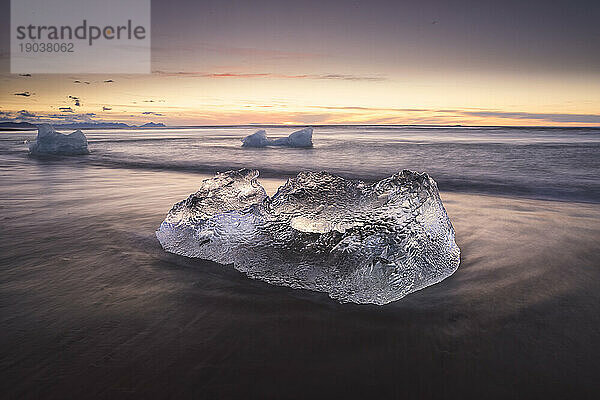 Sonnenaufgang am Diamond Beach mit Eisberg im Vordergrund