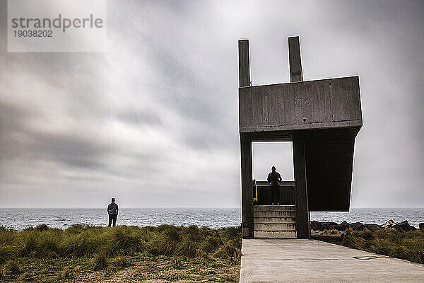 Zwei Personen am Betonwachturm am Meer  Lagoa  Azoren