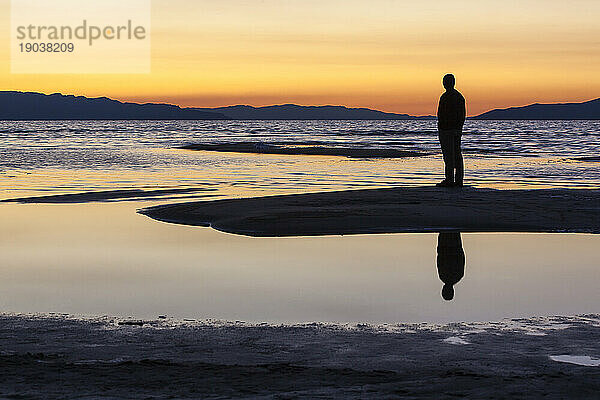 Silhouette eines Mannes an einem See.