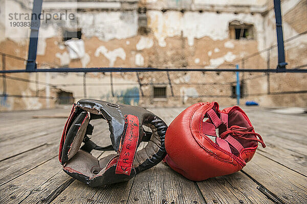 Zwei Kopfschützer sitzen nebeneinander auf dem provisorischen hölzernen Boxring im Project Cuba Boxeo  Alt-Havanna  La Havanna  Kuba