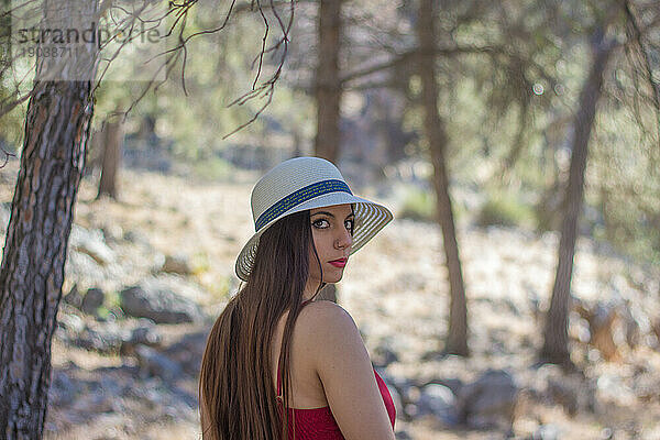 Eine junge Frau entspannt sich an einem sonnigen Frühlingstag in einem Wald