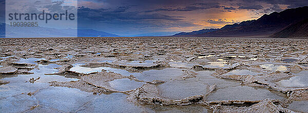 Die Salzebenen des Badwater-Beckens im Death Valley National Park  Kalifornien  spiegeln den dunklen Sonnenaufgang im Winter 2010.