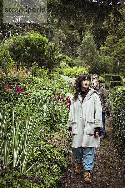 Mädchen spaziert friedlich mit der Familie durch den wunderschönen üppigen Garten