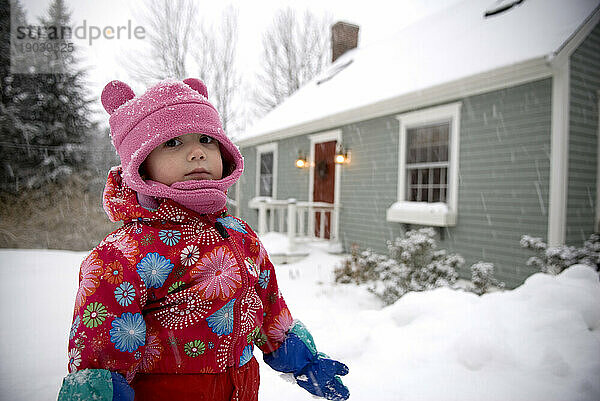 Junges Mädchen spielt im Schnee.