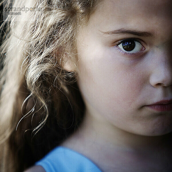 Ausgeschnittenes Vorderansicht-Porträt eines jungen Mädchens  das in die Kamera starrt.