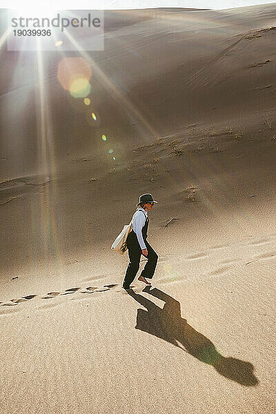 Eine Wanderin geht allein mit ihrem Schatten im großen Sanddünenpark spazieren