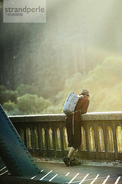 Eine Person genießt die Aussicht von einer Brücke.