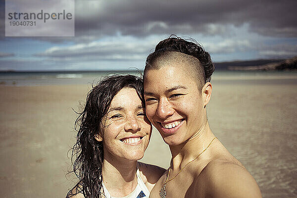 Romantic happy selfie by lesbian couple on beach