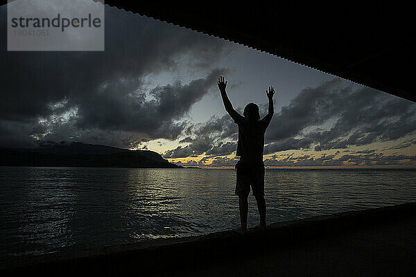 Silhouette einer Person  die den Sonnenuntergang beobachtet und die Hanalei Bay  Kauai erreicht