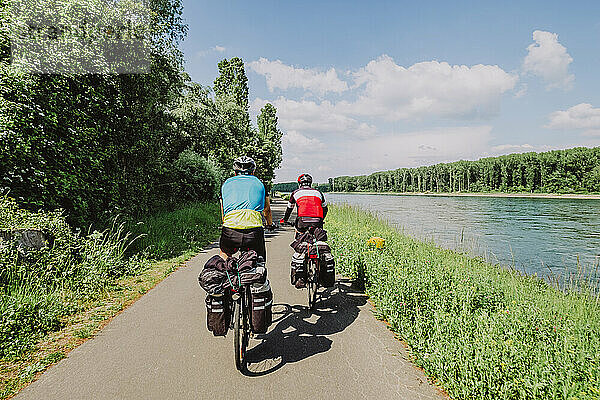 Zwei Radfahrer fahren mit ihren Fahrrädern in der Nähe des Flusses Rin  Deutschland