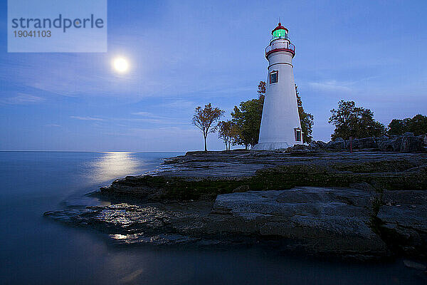 Der Mond geht über dem Eriesee am Marblehead Lighthouse in Marblehead  Ohio  USA auf.