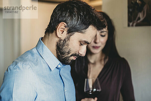 Frau trinkt Rotwein in der Küche