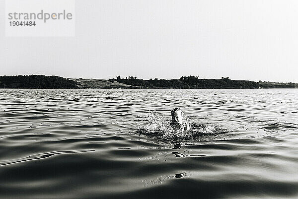 Kleines Mädchen schwimmt und planscht im See in North Dakota