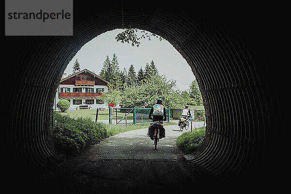 Radfahrer durchqueren einen Tunnel auf einer Romantischen Straße