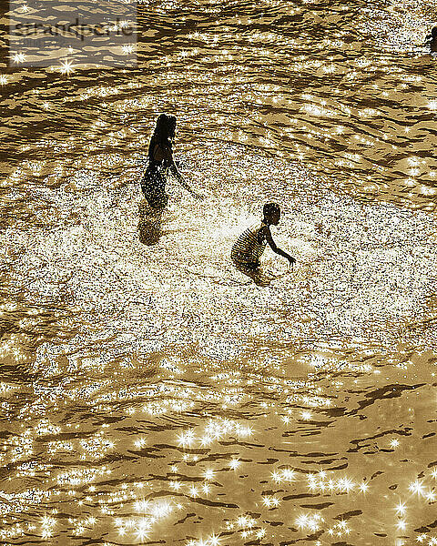 Zwei Kinder spielen in einem Fluss.